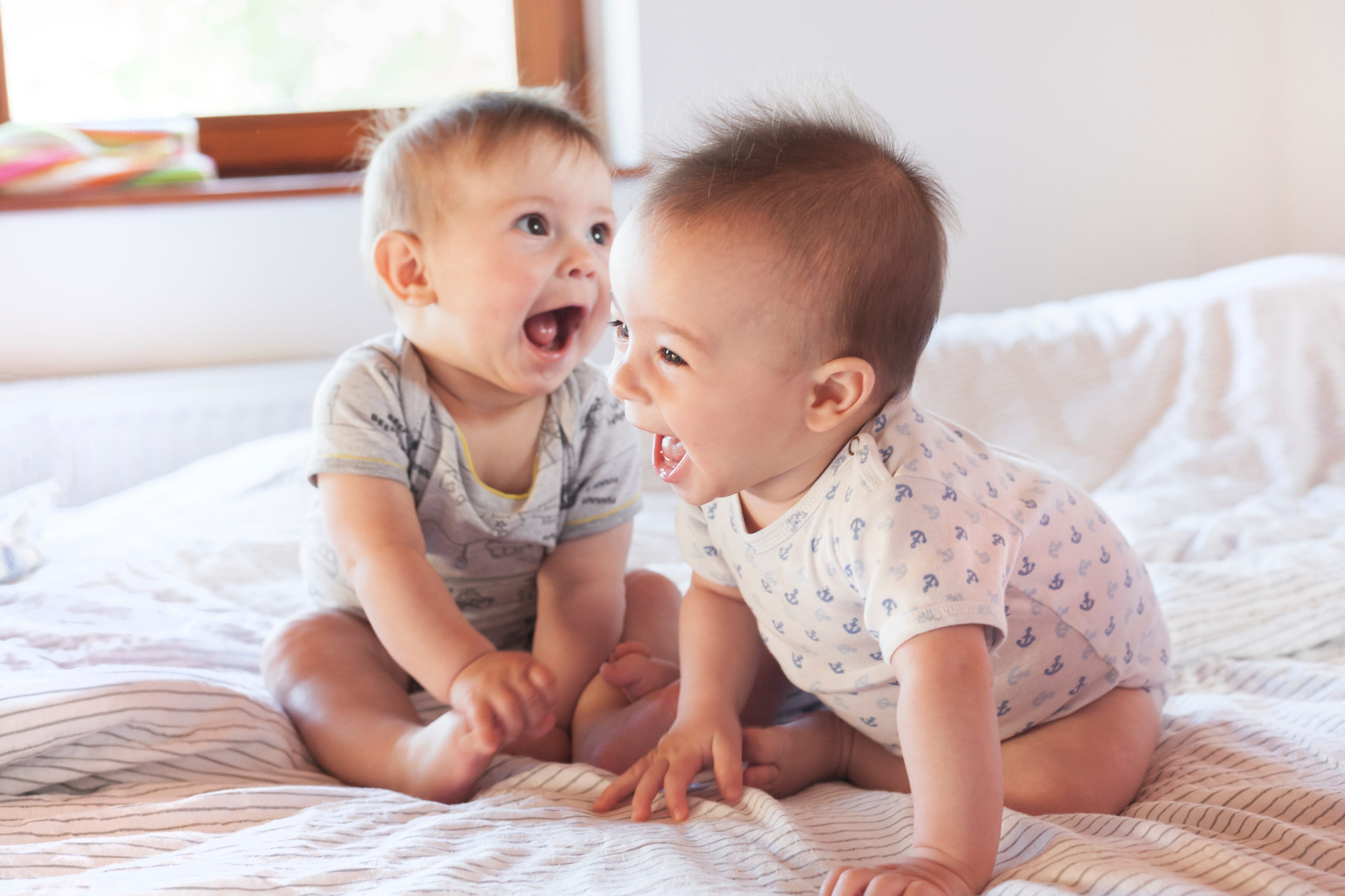 Deux bébés sur un lit qui rient